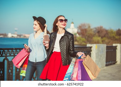 Two Girls Walking With Shopping On City Streets