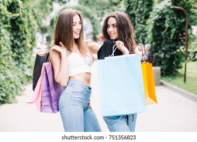 Two Girls Walking With Shopping On City Streets