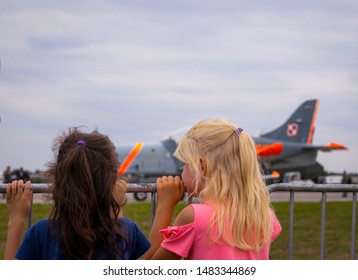 Two Girls Watching The Plane Take Off
