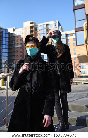 Two girls wearing medical mask outdoors on the street