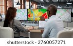 Two GIS Analysts In Office Using Computers To Review Urban Planning Maps. The Woman Checks Zoning Codes