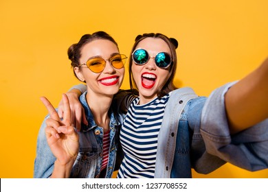 Two glad positive grinning lady stand in glasses spectacles street style stylish trendy cool casual denim jeans clothes isolated on yellow background in take picture on cellular make hollywood smile - Shutterstock ID 1237708552