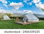 Two glamping sites on a sunny day with a beautiful mountain landscape in the background and a spectacular blue sky. Glamorous Camping