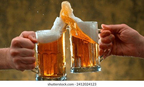 two glass of beer in hand. Beer glasses clinking in bar or pub - Powered by Shutterstock