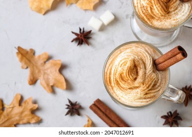 Two Glass Cups Pumpkin Latte With Spices On Grey Background With Autumn Leaves. View From Above.