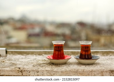 Two glass with delicious hot drink table in cafe street.Traditional black Turkish tea in tulip cup.Eastern tradition.Culture city Istanbul Turkey.Breakfast in morning terrace.International Tea Day