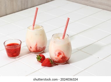 Two Glass Fresh Korean Strawberry Milk with Homemade Strawberry Compote Sauce on White Background, Copy Space for Text