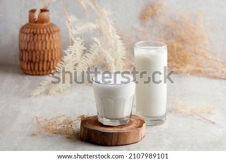 Two Glass jar of babyccino drink with whipped milk or cream. Isolated on wood. Drink for babies
