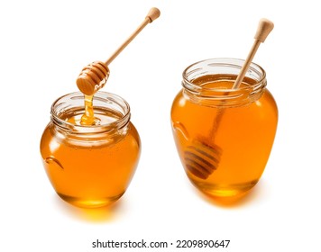 Two glass jars with liquid honey set isolated on white background. Wooden dippers. Package design elements with clipping path - Powered by Shutterstock