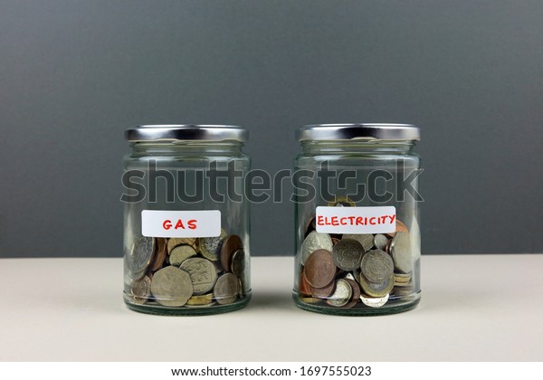 Two Glass Money\
Jars With Labels Indicating Gas And Electricity. Saving To Pay\
Household Energy Bills\
Concept.