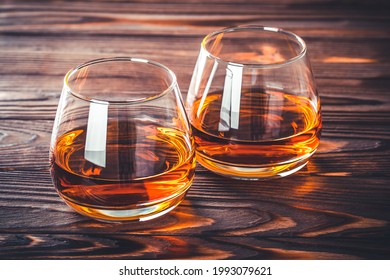 Two Glass Of Whiskey, Cognac, Brandy On A Dark Brown Wooden Table. Bourbon. Strong Alcohol Drink Close-up. Rum, Scotch. Still Life In A Rustic Style.