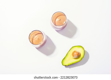 Two Glasses With Avocado Chocolate Smoothie With Ingredients On White Background. Top View, Flat Lay