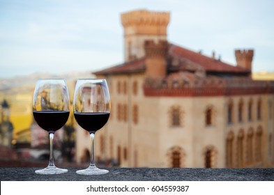 Two glasses of Barolo wine on a windowsill with the castle of Barolo (Piedmont, Italy) blurred on the background