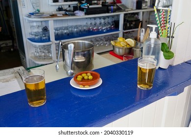 Two Glasses Of Beer And Olives On A Beach Bar Counter