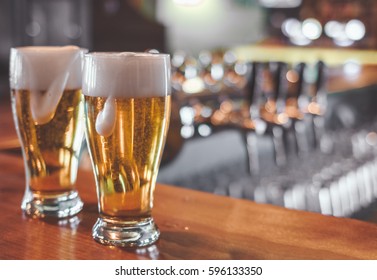 Two  Glasses of Beer on a bar table. Closeup. - Powered by Shutterstock