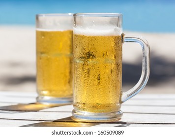 Two Glasses Of Beer On A Beach 