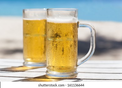 Two Glasses Of Beer On A Beach 