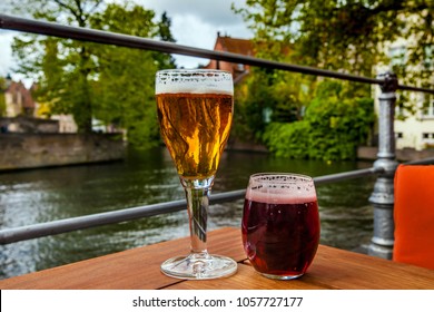 Two glasses of belgian beer standing on the table with Bruges city view