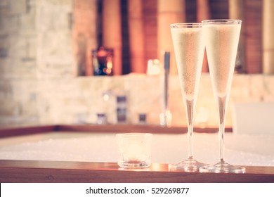 Two glasses of champagne with candle near jacuzzi. Valentines background. Romance concept. Horizontal, toned