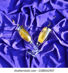 Two Glasses Of Champagne On A Silk Blue Background. Minimalist Celebration Concept. Flat Lay. Copy Space.