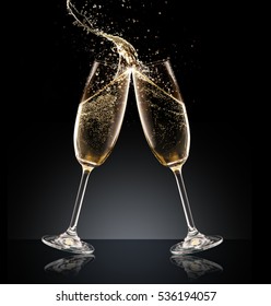 Two glasses of champagne with splash over black background. Celebration concept