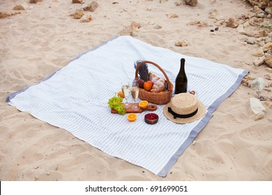 Two glasses of champagne. Summer Picnic on the beach at sunset in the white plaid, food and drink conception.