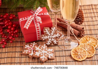 Two Glasses With Champange, Gift Boxes And Christmas Ginger Cookies Standing On A Table Near Fir Tree. New Year And Christmas.