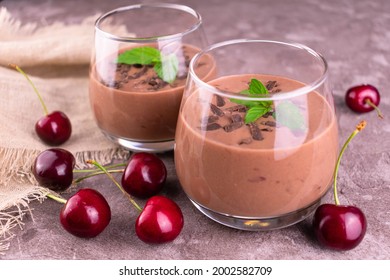 Two Glasses With Chocolate Cherry Smoothies On A Gray Background.