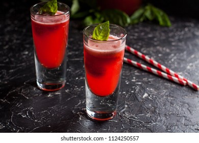 Two Glasses Of Freshly Made Strawberry Basil Lemonade With Swirly Straws On Dark Table