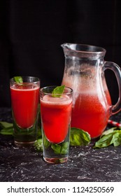 Two Glasses Of Freshly Made Strawberry Basil Lemonade With Swirly Straws On Dark Table