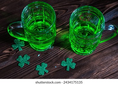 two glasses of green Irish beer, evoking the lively atmosphere of celebration in a traditional pub setting. St. Patrick's Day concept - Powered by Shutterstock