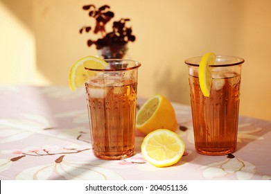 Two Glasses Of Iced Tea With Lemon Outdoor With Sunlight On The Table