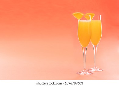 Two Glasses Of Mimosa Cocktail On Coral Pink Background, Copy Space