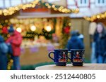 Two glasses mugs with mulled wine or punch on Christmas Market in Germany. Traditional alcoholic drinks on German xmas funfair