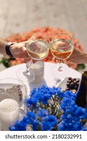 Two Glasses Of Red Or White Wine Close-up In Hands Outside The House. Man And Woman In Love Make The Clink Of Glasses. Celebrate Valentine's Day, Date. Warm, Blurred Background, Countryside Relaxation