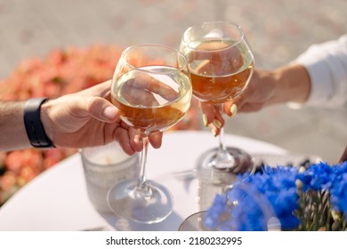 Two Glasses Of Red Or White Wine Close-up In Hands Outside The House. Man And Woman In Love Make The Clink Of Glasses. Celebrate Valentine's Day, Date. Warm, Blurred Background, Countryside Relaxation