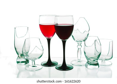 Two Glasses Of Red Wine And Broken Glasses. White Background