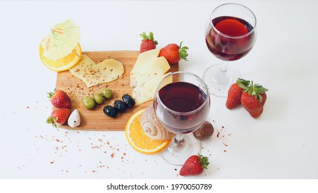 Two glasses of red wine and cheese platter. - Powered by Shutterstock