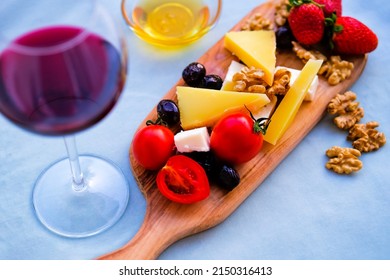 Two Glasses Of Red Wine And Cheese Plate On The Table At The Balcony. Fine Dining At Home.