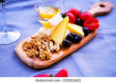 Two Glasses Of Red Wine And Cheese Plate On The Table At The Balcony. Fine Dining At Home.