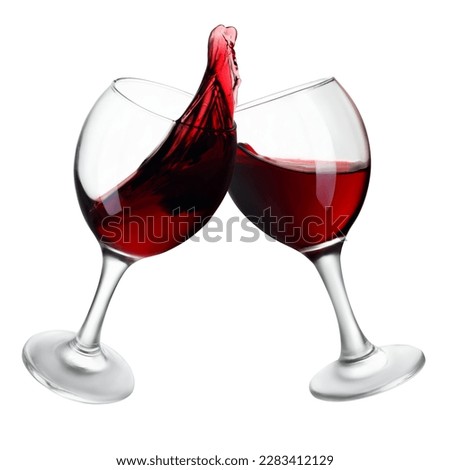 two glasses of red wine making toast with splash isolated on white background