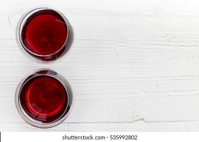 Two Glasses Of Red Wine On White Wooden Background From Top View