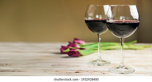 Two Glasses Of Red Wine And Tulips On A Wooden Background. Spring Flowers, Calabration, International Womens Day.