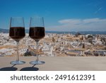 Two glasses of red wine with view of Cordoba city center from above, Spain