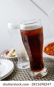 Two glasses of refreshing cola and sprite with ice, perfect for a cool drink.