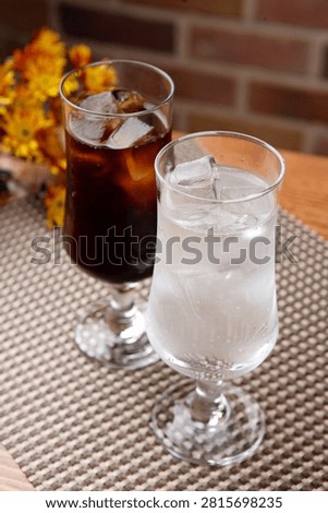 Two glasses of refreshing cola and sprite with ice, perfect for a cool drink.