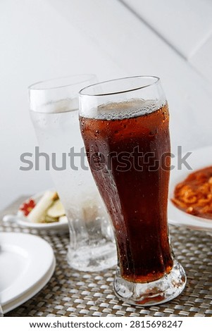 Two glasses of refreshing cola and sprite with ice, perfect for a cool drink.
