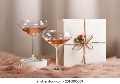 Two Glasses With Rose Wine And Decorated Gift
