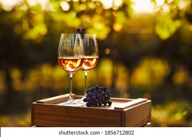 Two glasses of rose wine on a wooden crate in the vineyard - Shutterstock ID 1856712802