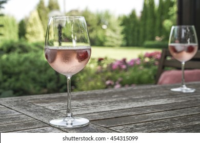 Two Glasses Of Rose Wine On Table At Garden In A Sunny Day